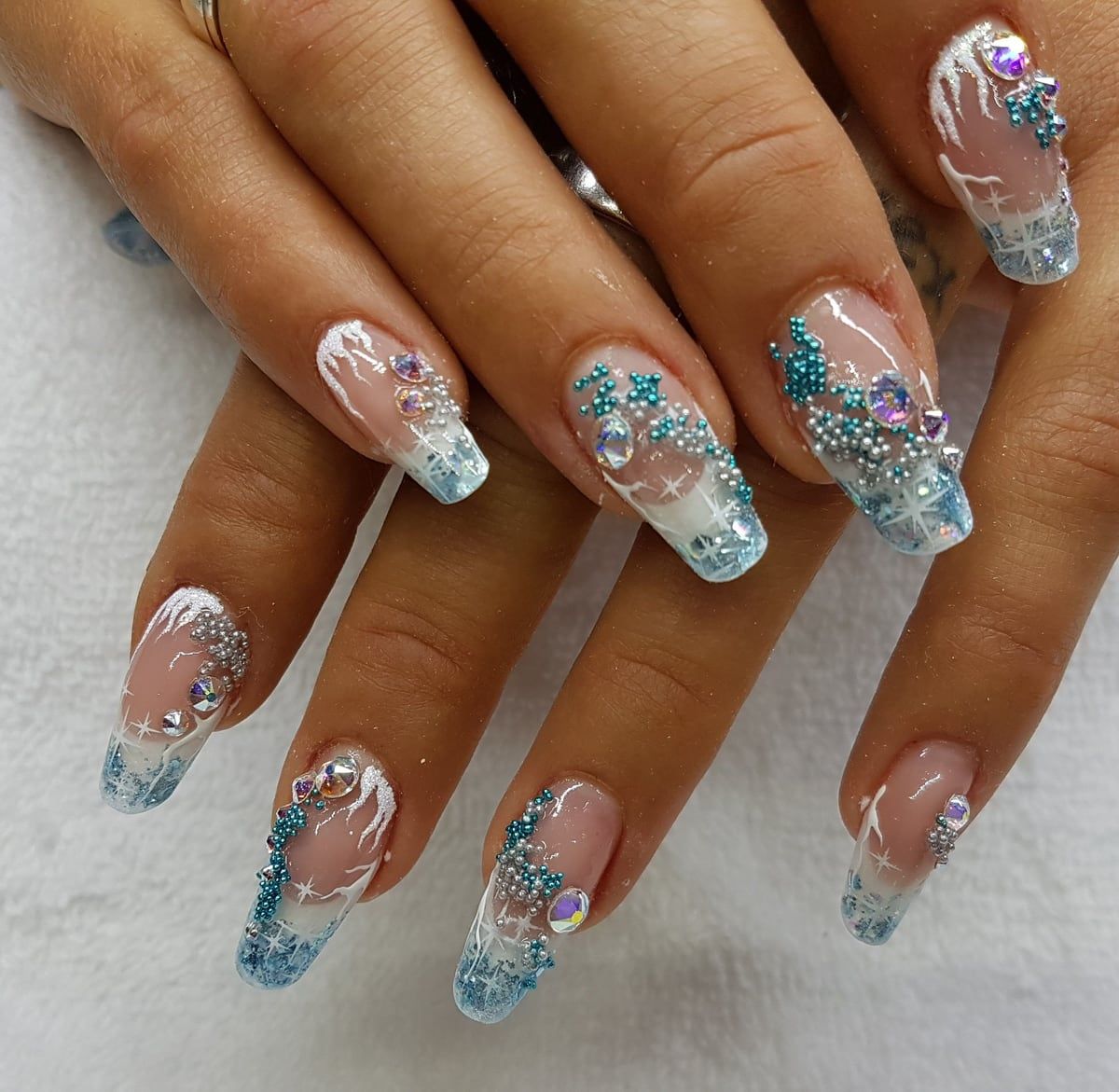 Gelnägel in Rosé und Eisblau mit weißen Linien, Perlchen und Strasssteinen.