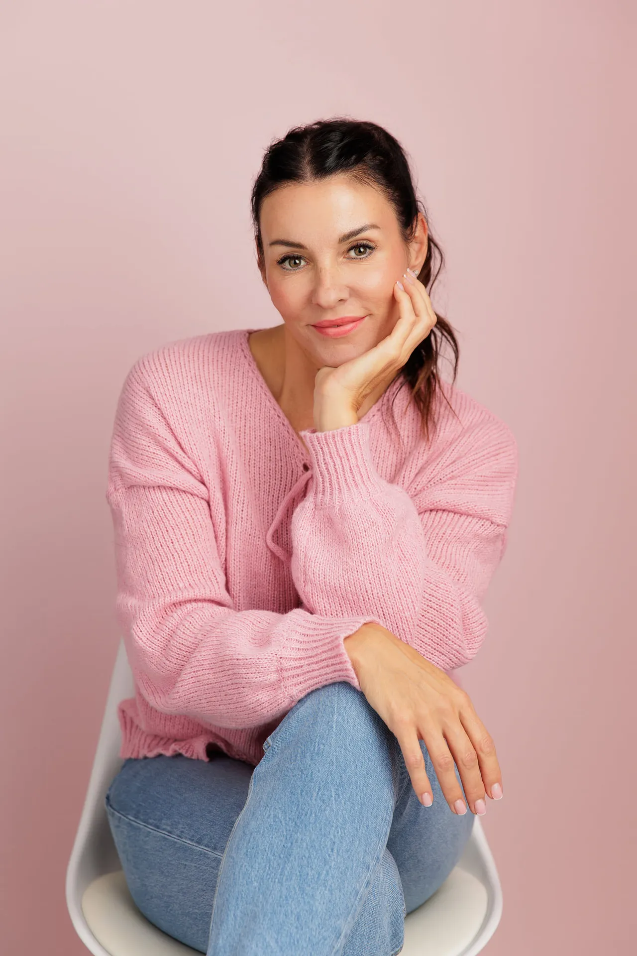 Sabrina Lindenau im rosa Pullover, auf einem Stuhl sitzend.